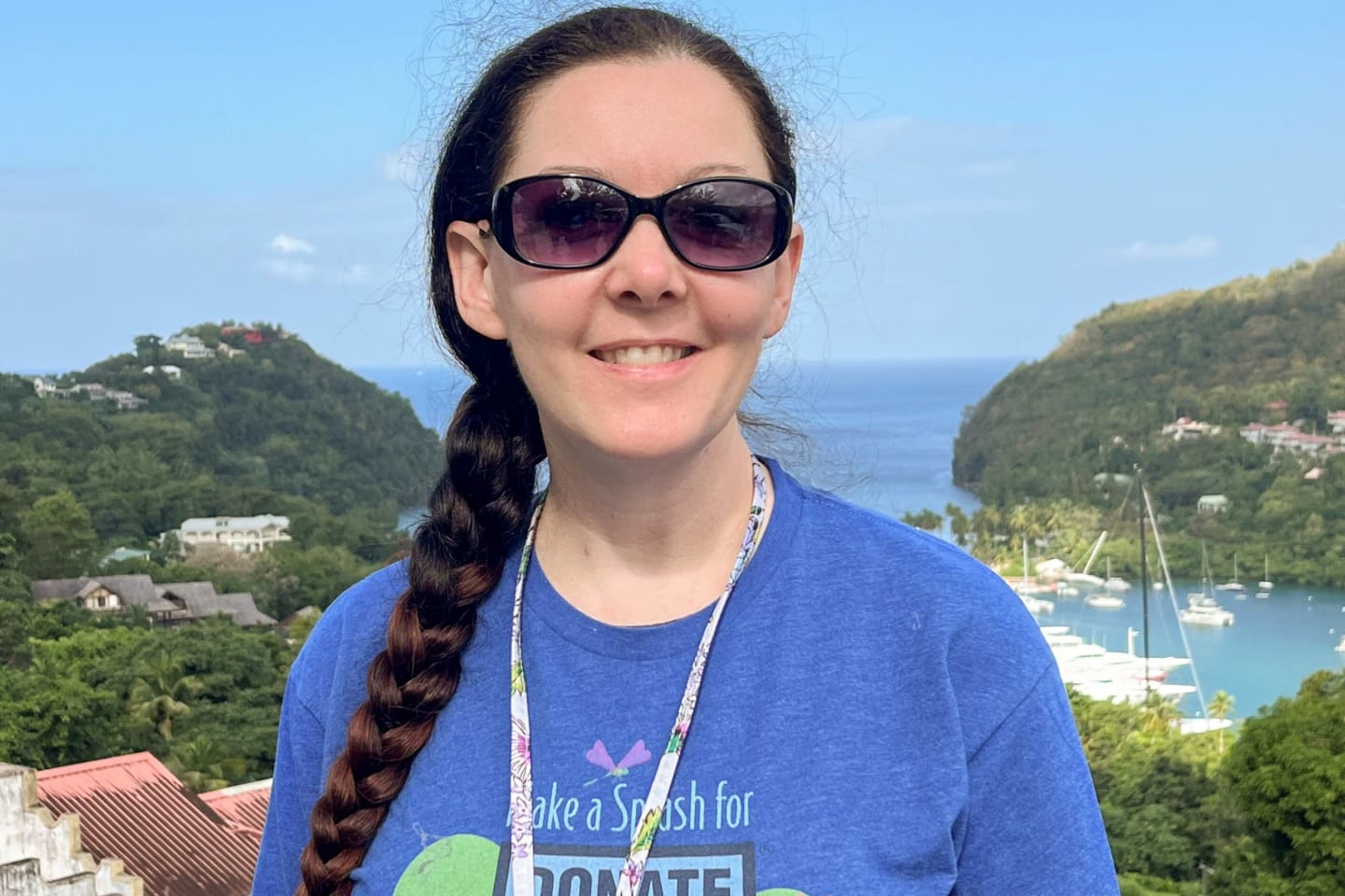 Woman smiling outdoors with sunglasses and a shirt that says, "Donate Life."