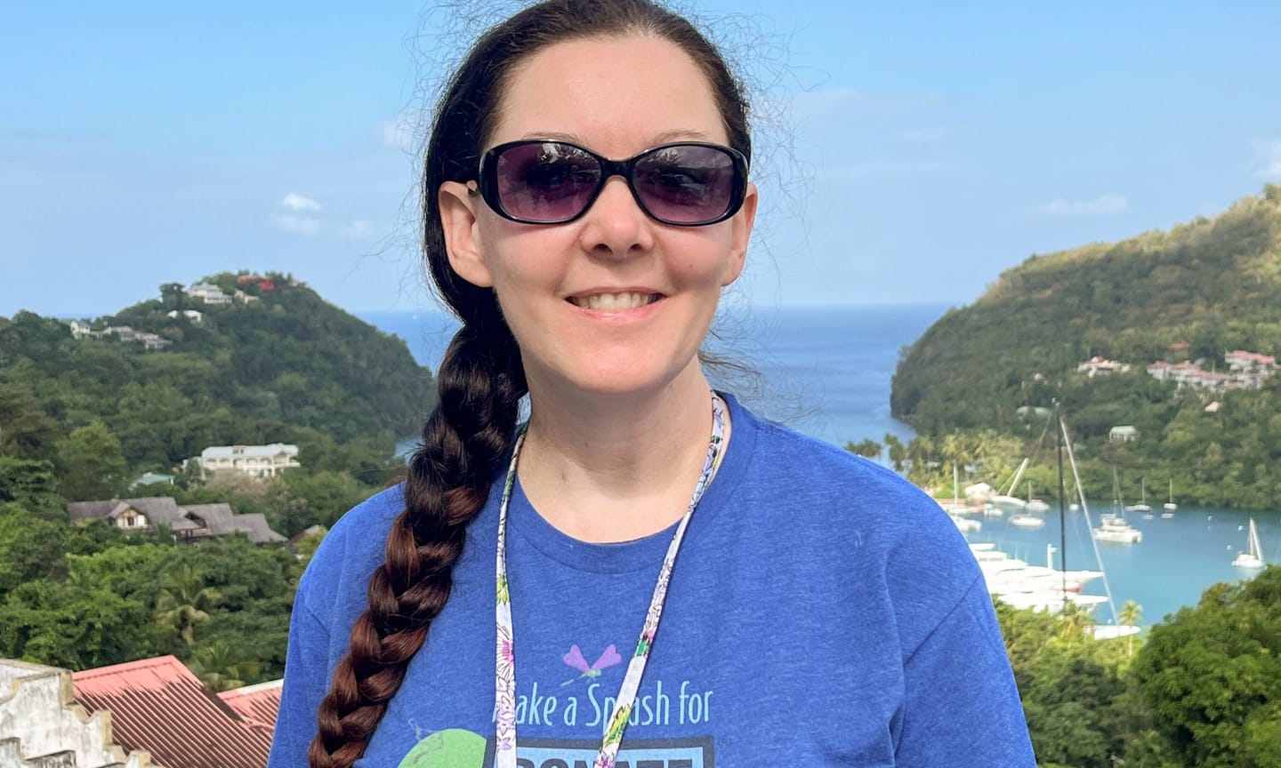 Woman smiling outdoors with sunglasses and a shirt that says, "Donate Life."