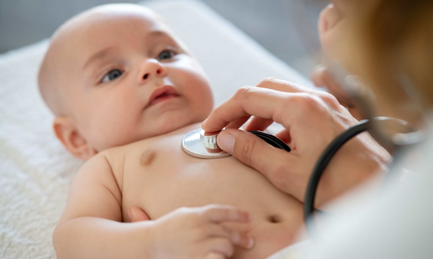 Provider listening to an infant's chest with a stethoscope
