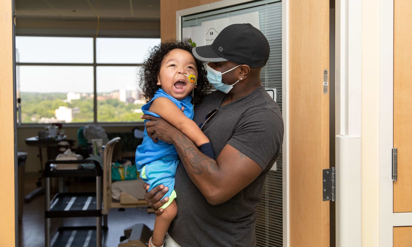 Two-year-old Kingston and his dad standing in the hospital