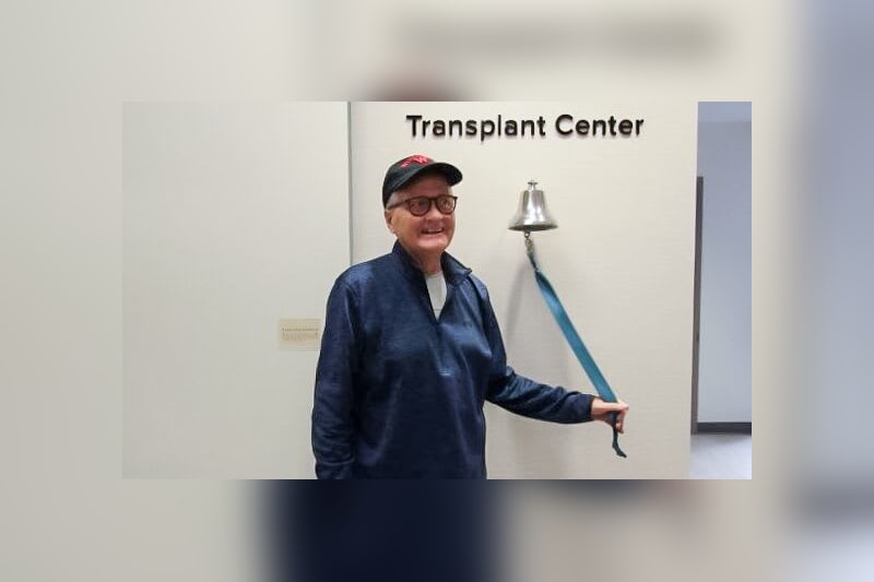 Tim Knurr ringing the bell at the UW Health Transplant Center, signifying a successful liver transplant.