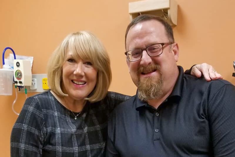 Joel Everts, as an adult, reunites with Sharon Frierdich inside a clinic exam room