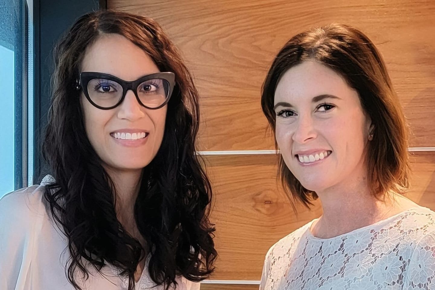 Two women standing next to each other and smiling