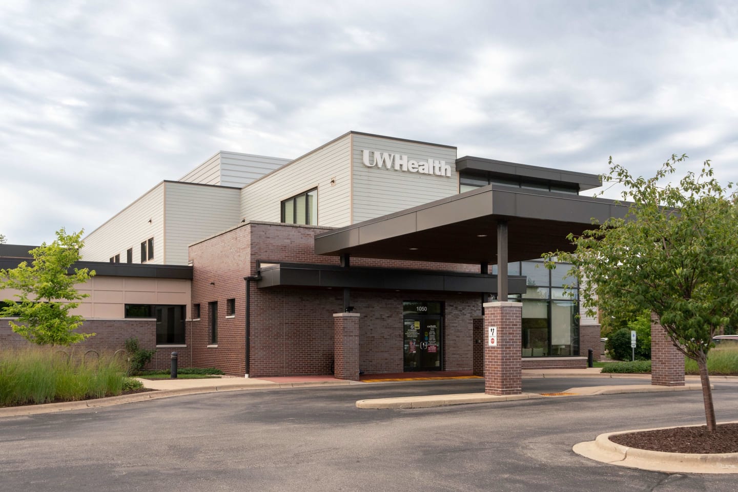 Tan and brick building with white UW Health logo at the top