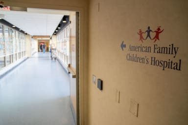 A sign in a hallway pointing to American Family Children's Hospital