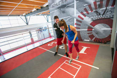 A UW Health athletic trainer working on a track with a sprinter