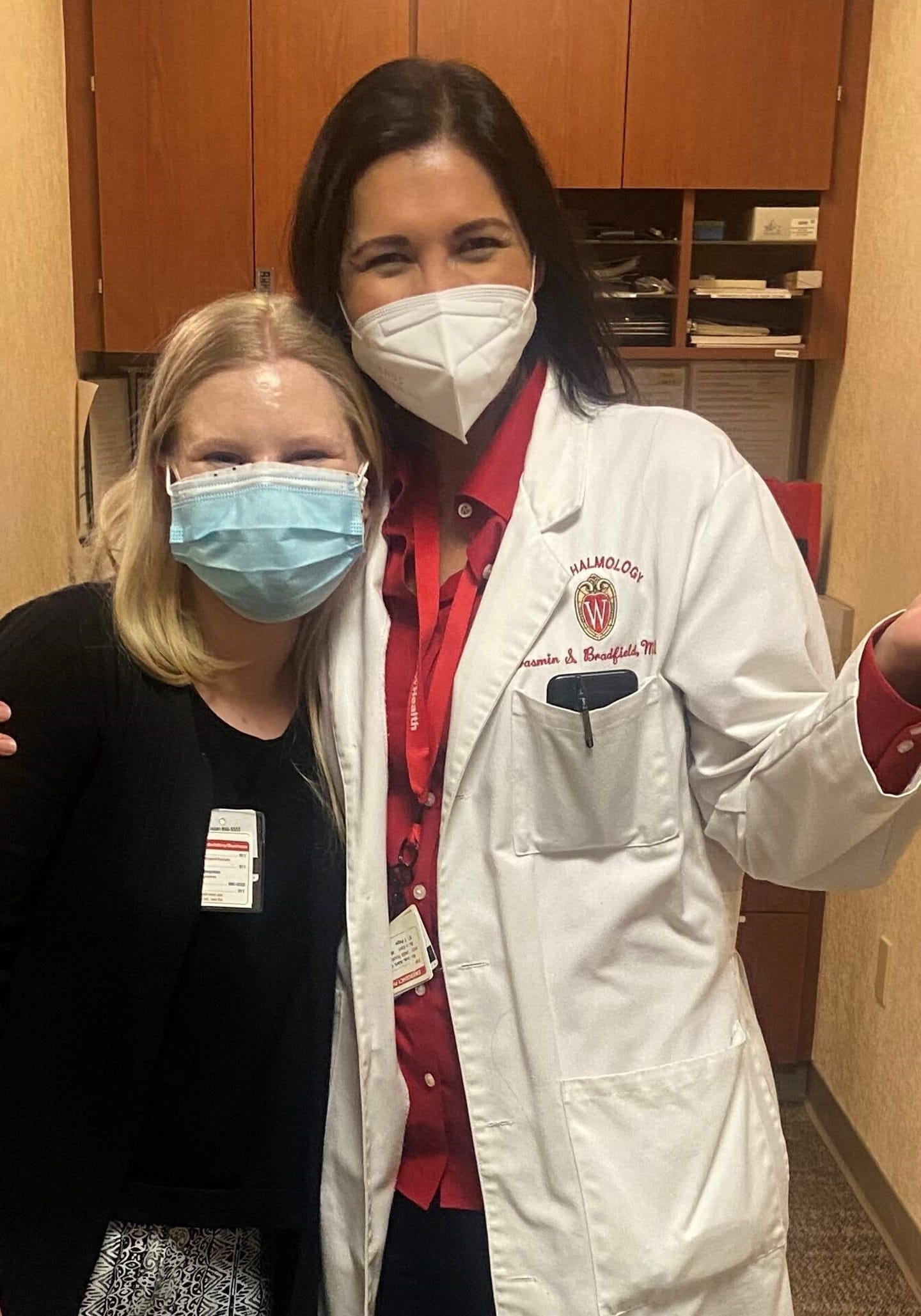 Veronica Blumer and Doctor Yasmin Bradfield standing in a hallway, wearing face masks