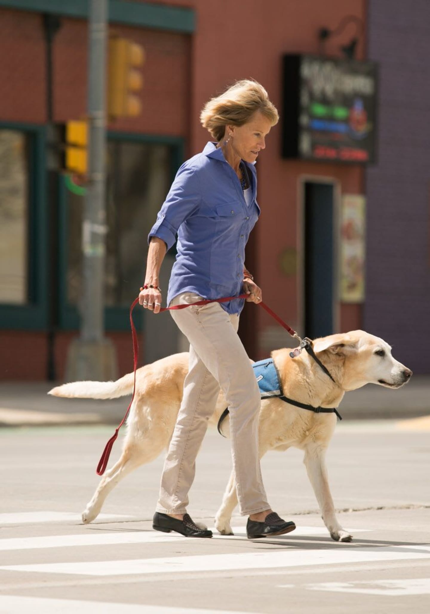 Lisa Steinkamp walking her dog across a crosswalk