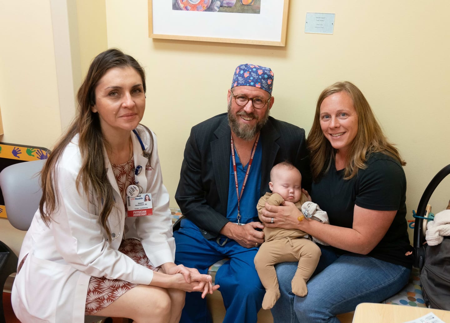 A baby being held by a physician in an exam room