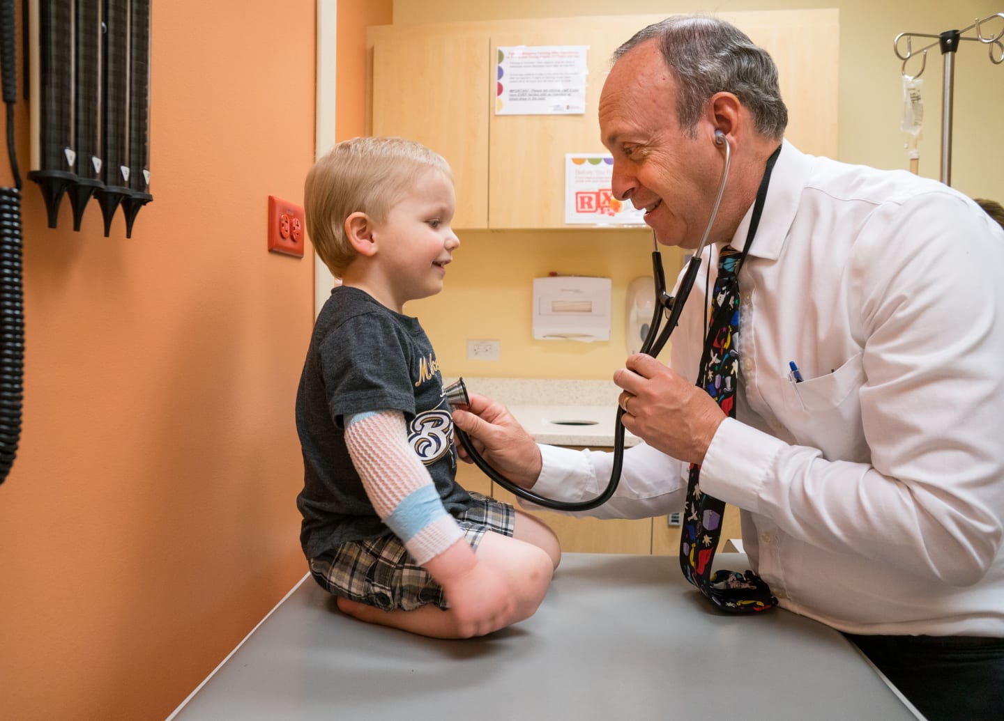 A physician listening to a child's lungs and heart with a stethoscope