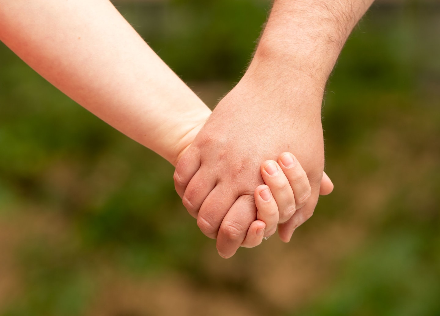 A closeup of two people holding hands