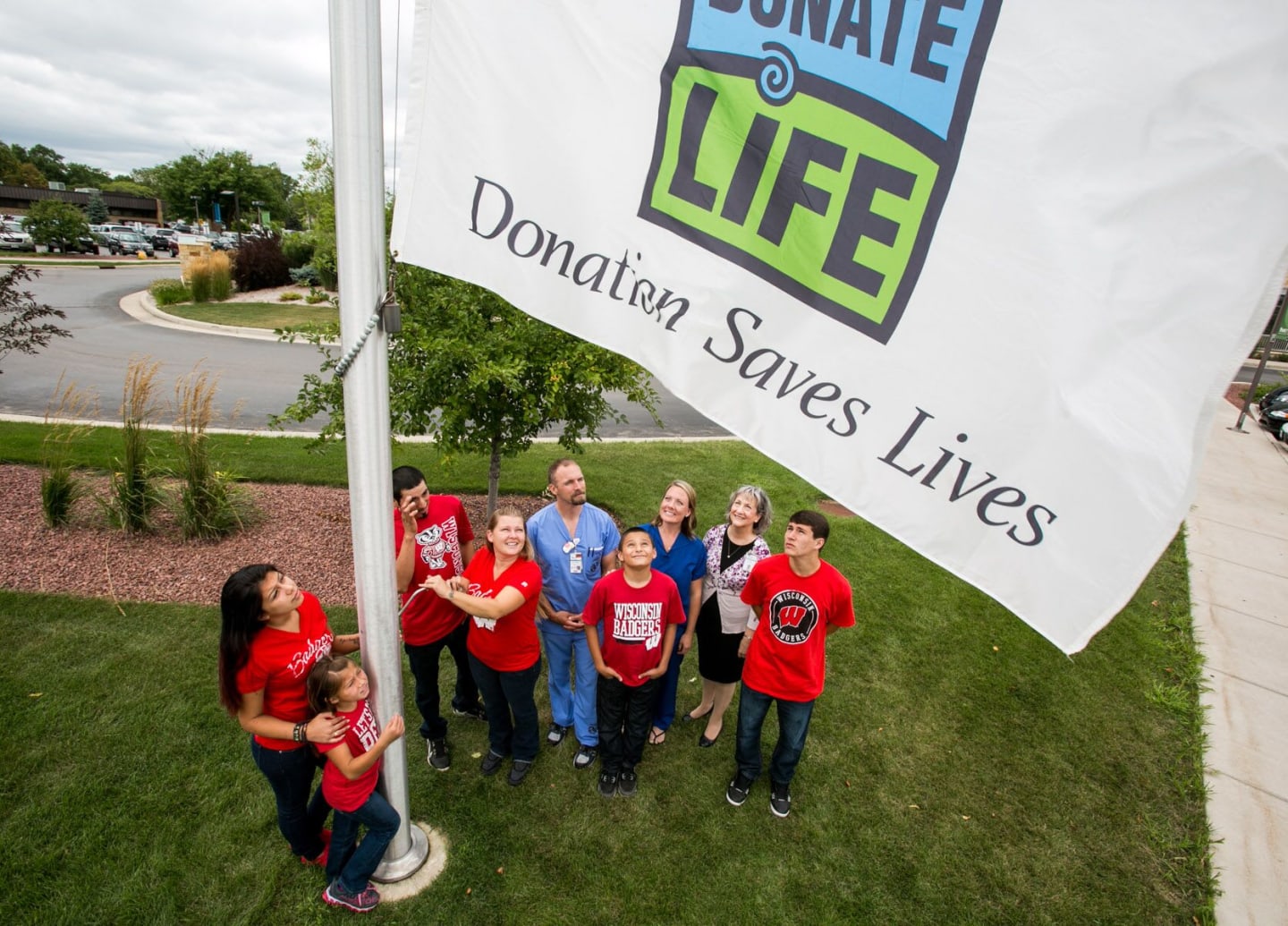 A group raising the Donate Life flag on a flag pole.