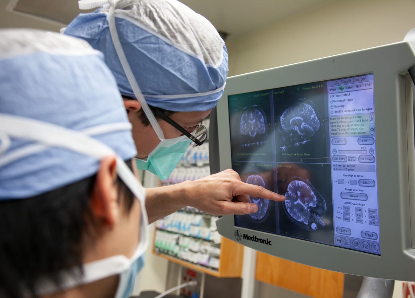 Two medical providers reviewing brain scans on a monitor