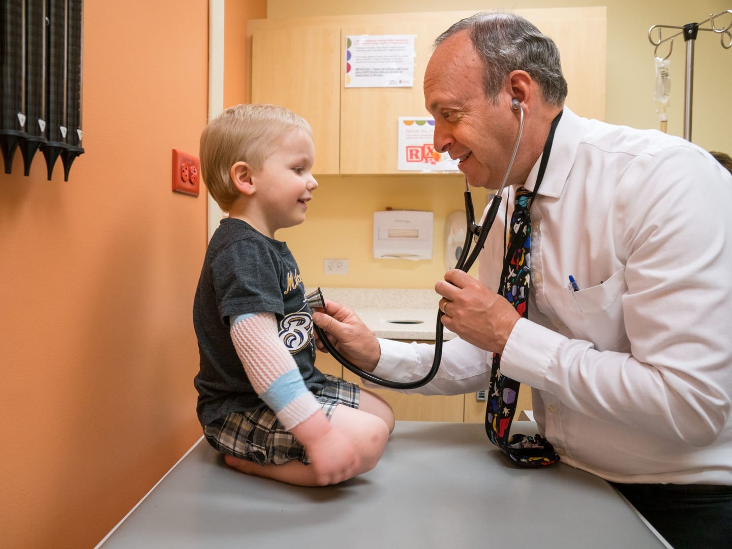 A physician listening to a child's lungs and heart with a stethoscope