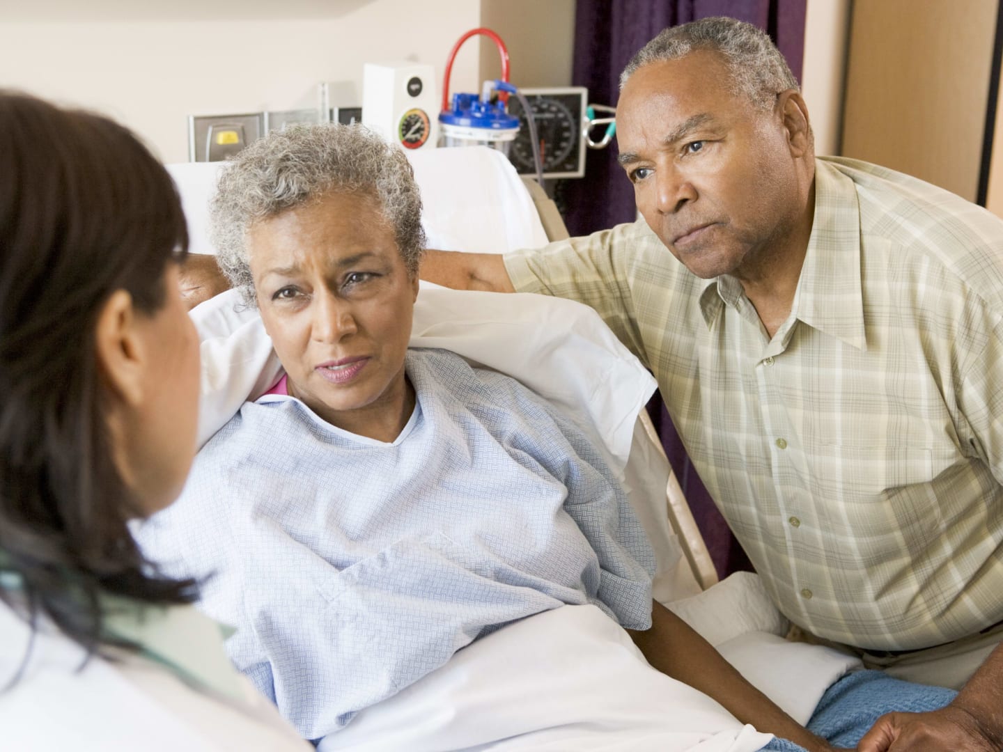 A physician talking to a couple next to a hospital bed