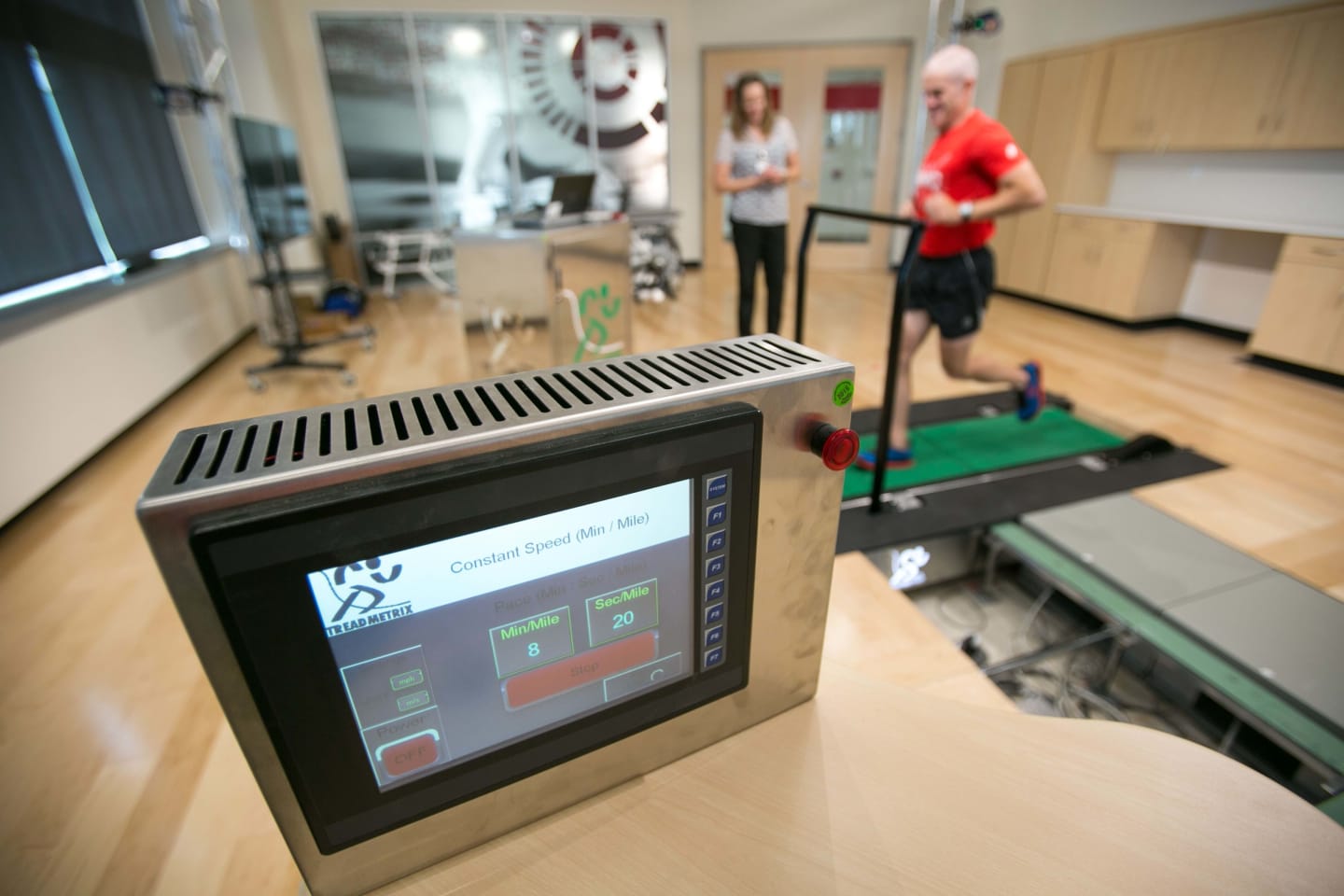 A UW Health athletic trainer working with an athlete on a pressure sensitive treadmill