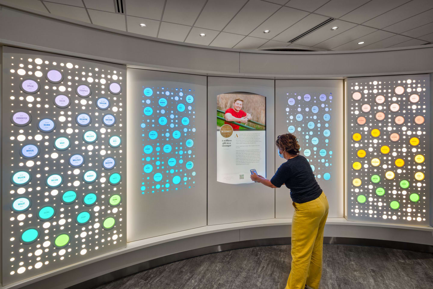 A visitor scans a barcode to read more about a patient featured on the Living Donor Wall