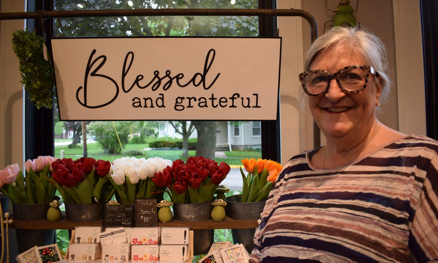Lynn McFee standing next to several potted plants