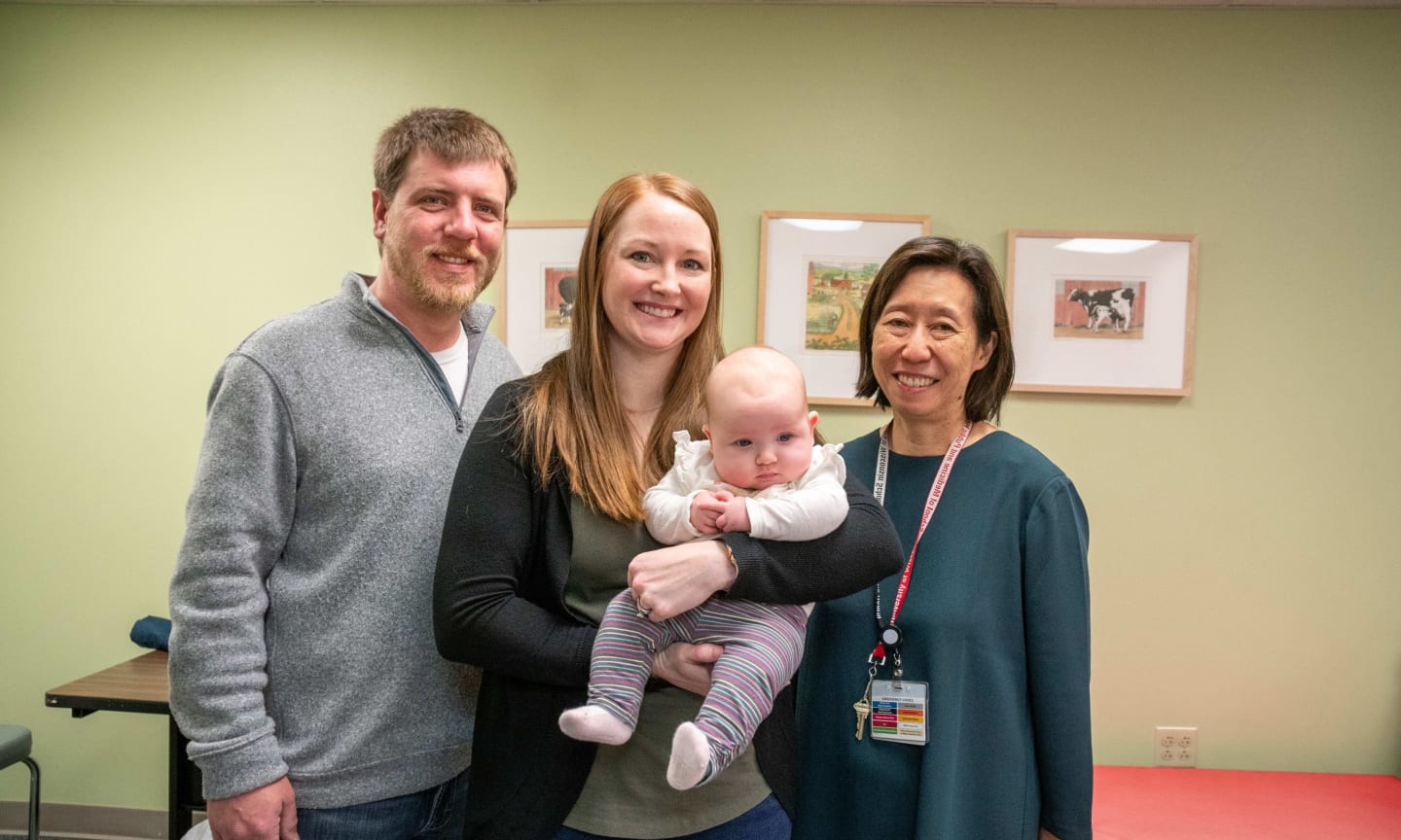 Baby Piper Droessler being held by parents Caiti and Ben and their doctor, Jennifer Kwon