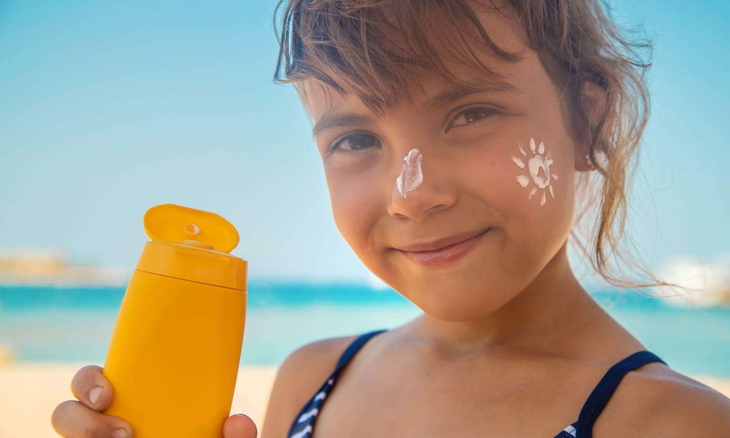 A child wearing sunscreen on their nose