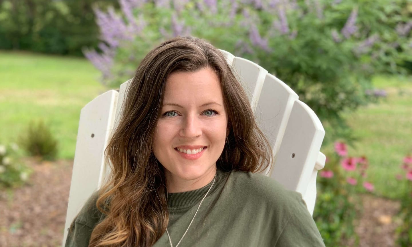 Heather Allsbrooks sitting in a white adirondack chair