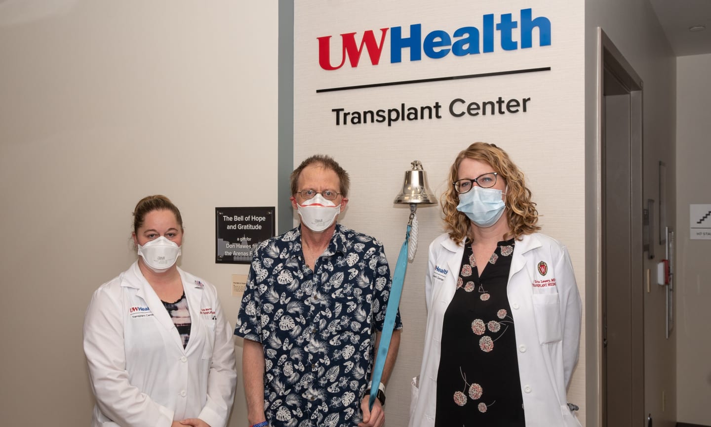 A transplant patient posing for a photo with two of his doctors