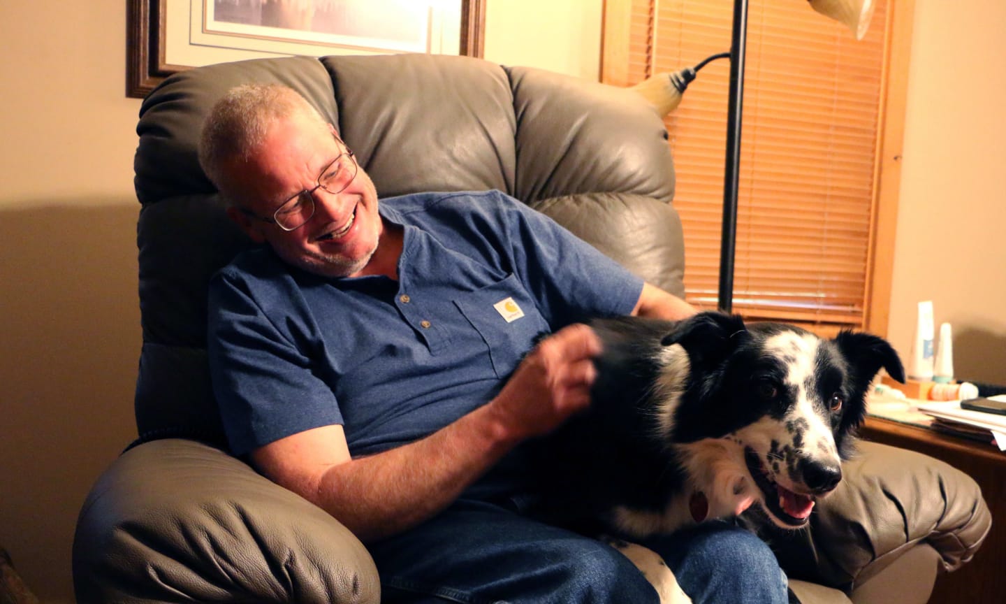 Man sitting on chair with his dog