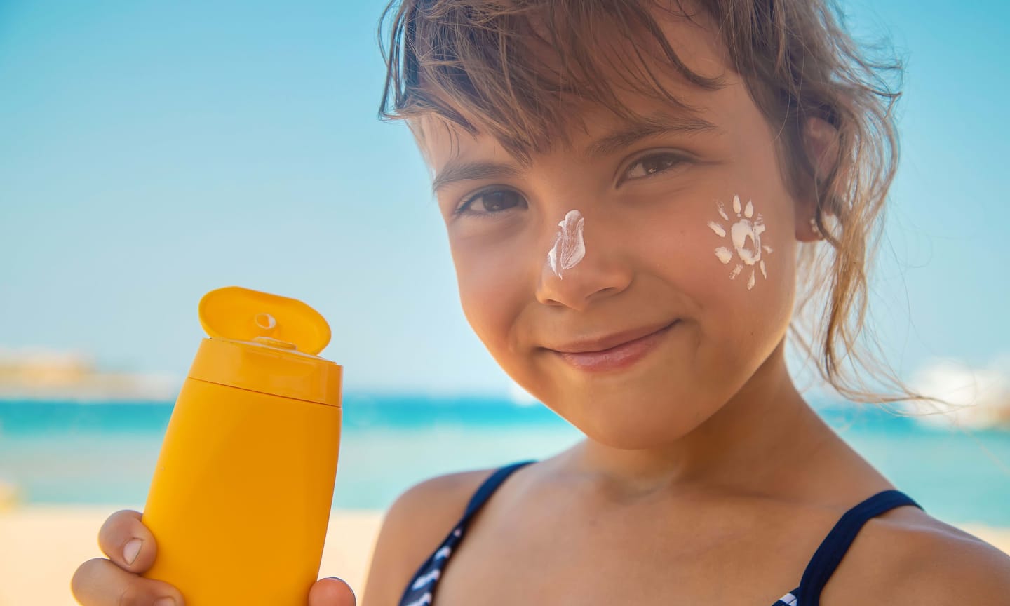 Girl on the beach with sunscreen