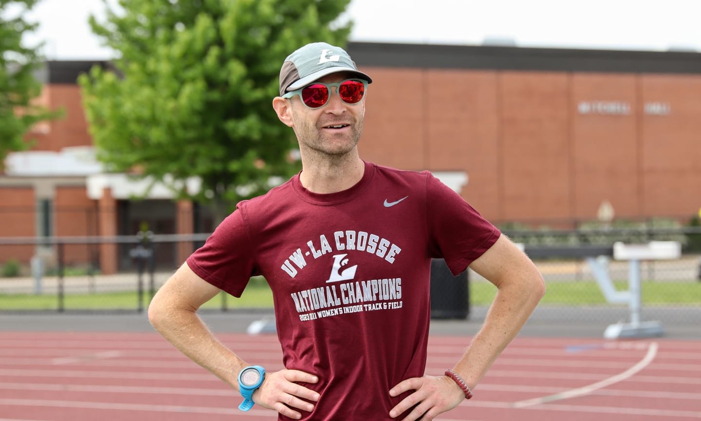 A man in sunglasses standing on a track at the University of Wisconsin La Crosse