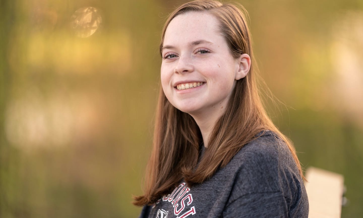 Kate Wester, smiling outdoors in a grey shirt.