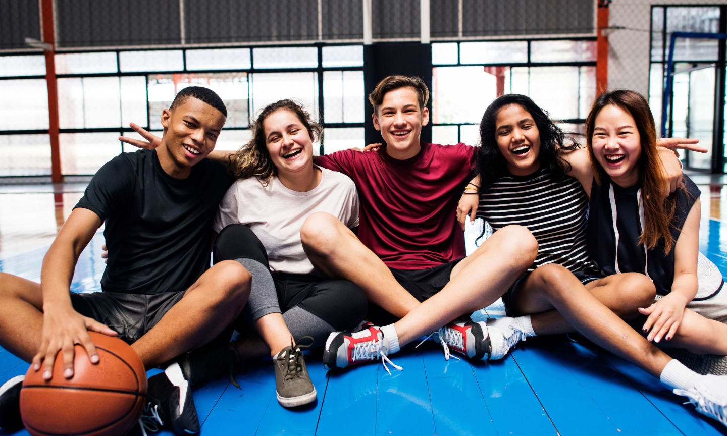 Group of young teenager friends on a basketball court relaxing portrait