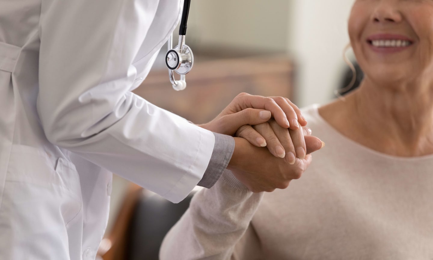 Close up of a doctor holding a patient's hand