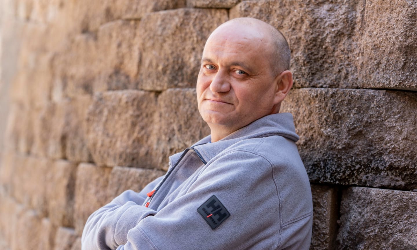 Krystian Marut leaning against a stone wall.