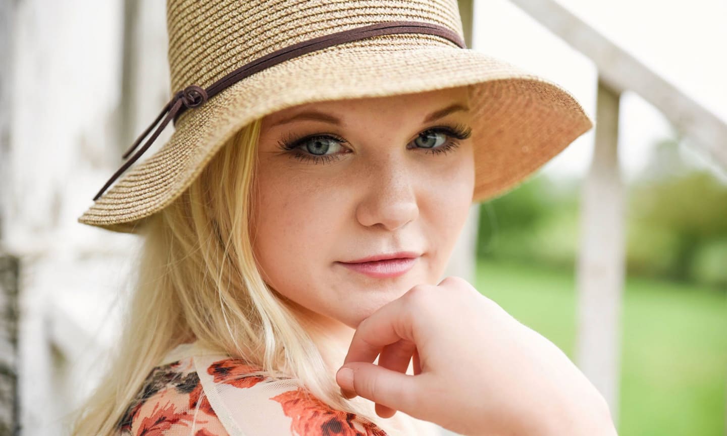 Breelyn Neuroth, smiling outdoors in a sun hat.