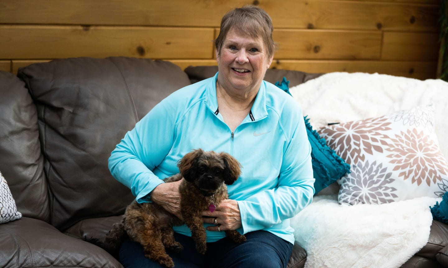 Carol Albright smiling and holding her dog