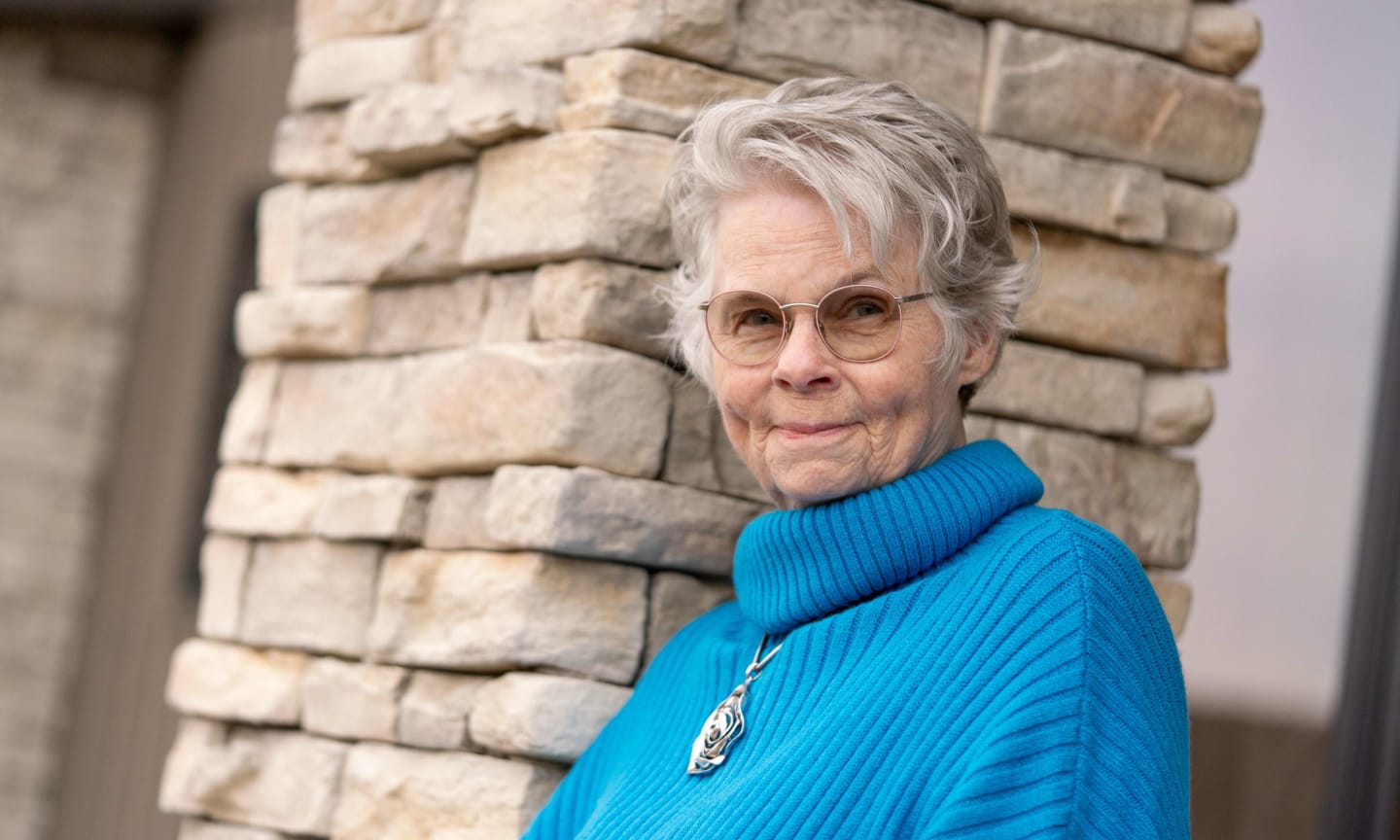 Danita Doyle smiling outdoors in a blue sweater.