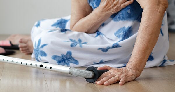 An older adult sprawled across the ground after falling