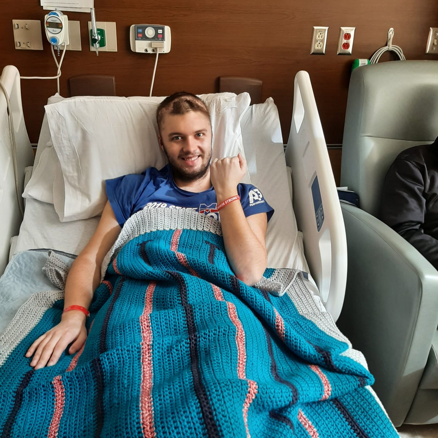 Connor Keith in hospital bed, smiling as he recovers.