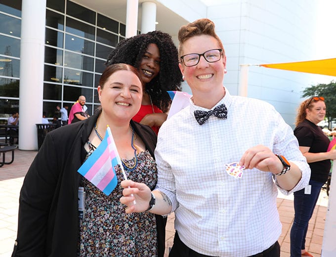 Two happy team members waving a trans rights flag