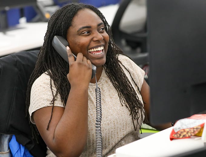 An Underwriting team member smiling while taking a call