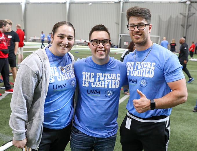 Three happy team members sharing a fun sporting event together