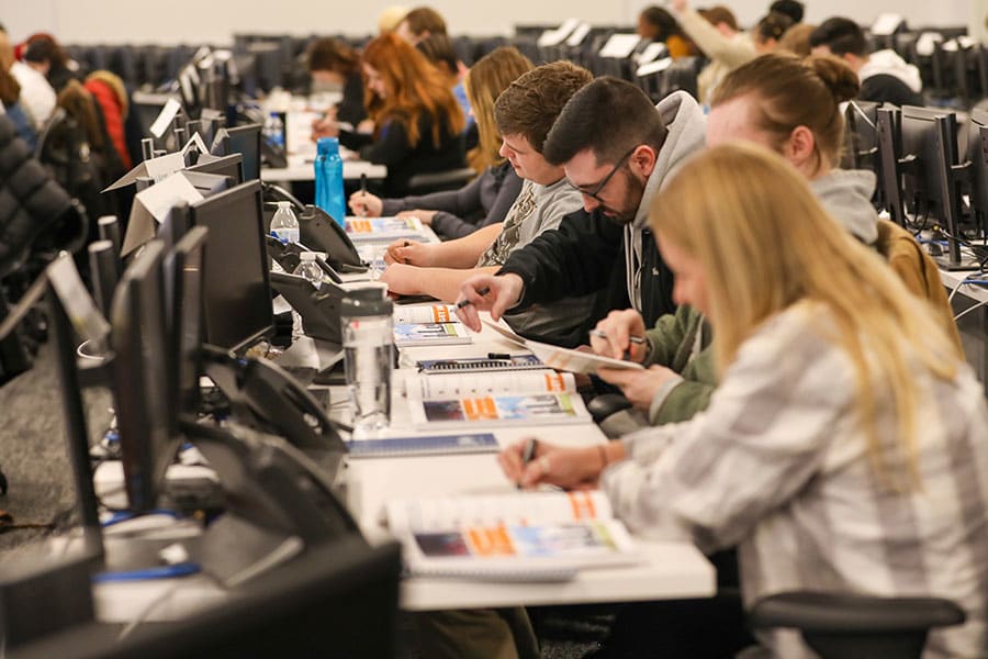 People taking a test at a row of desks