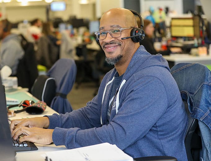 A happy Client Experience team member at a desk