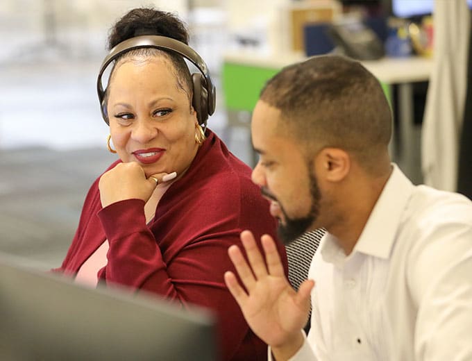 Two Capital Market team members working together at a deck