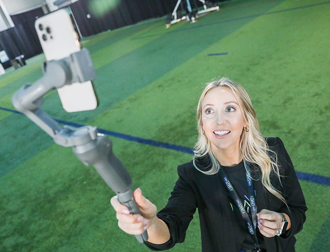 A Marketing team member taking a selfie with a phone on a gimbal