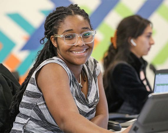 A smiling UWM Intern sitting at her desk
