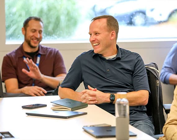 Smiling team members sitting at a desk together