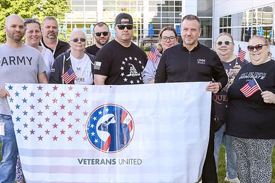UWM team member Veterans holding a Veterans United Team Member Resource Group flag