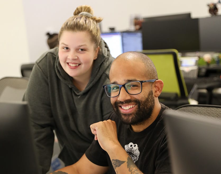 Two Mortgage Operations team member smiling at a desk