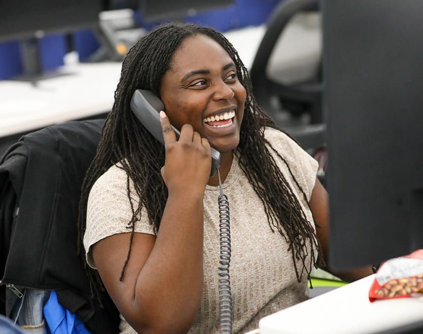 A smiling Underwriting team member taking a call